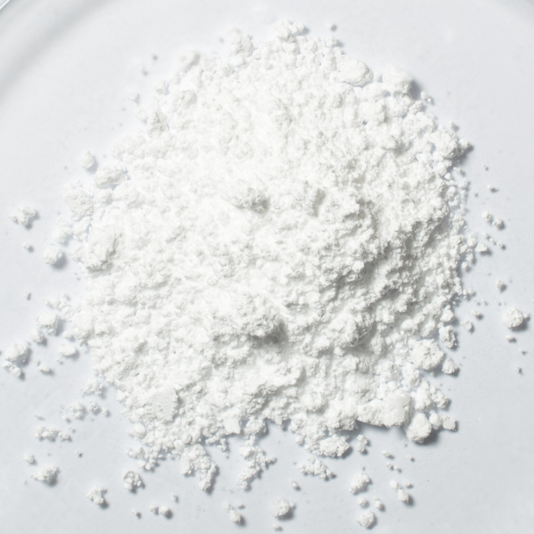 Weißes Focusmind Pro© Pulver mit Kreatin, Niacin und Selen als Close-up auf hellem Hintergrund