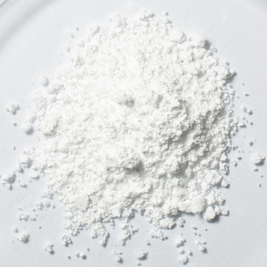 Weißes Focusmind Pro© Pulver mit Kreatin, Niacin und Selen als Close-up auf hellem Hintergrund