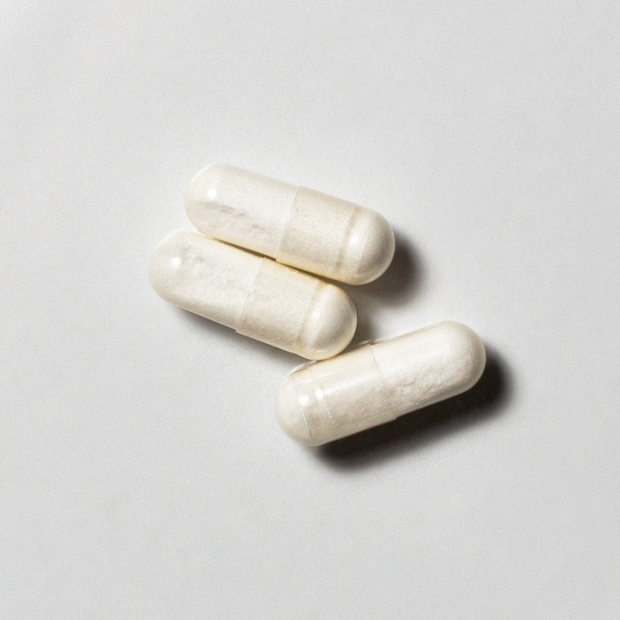 White vegan neotes Lambda Plus capsules in close-up on a light background