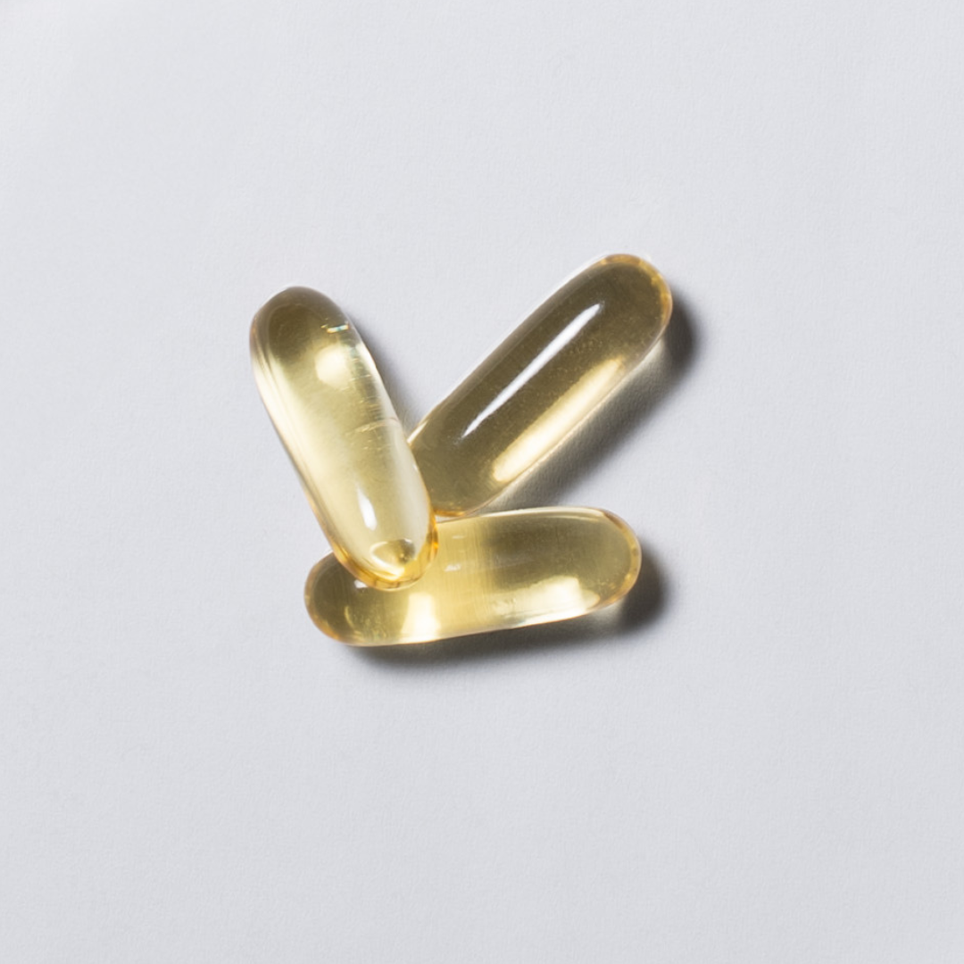 Gelbe Omega-3 Softgel-Kapseln von neotes im Close-up auf hellem Hintergrund