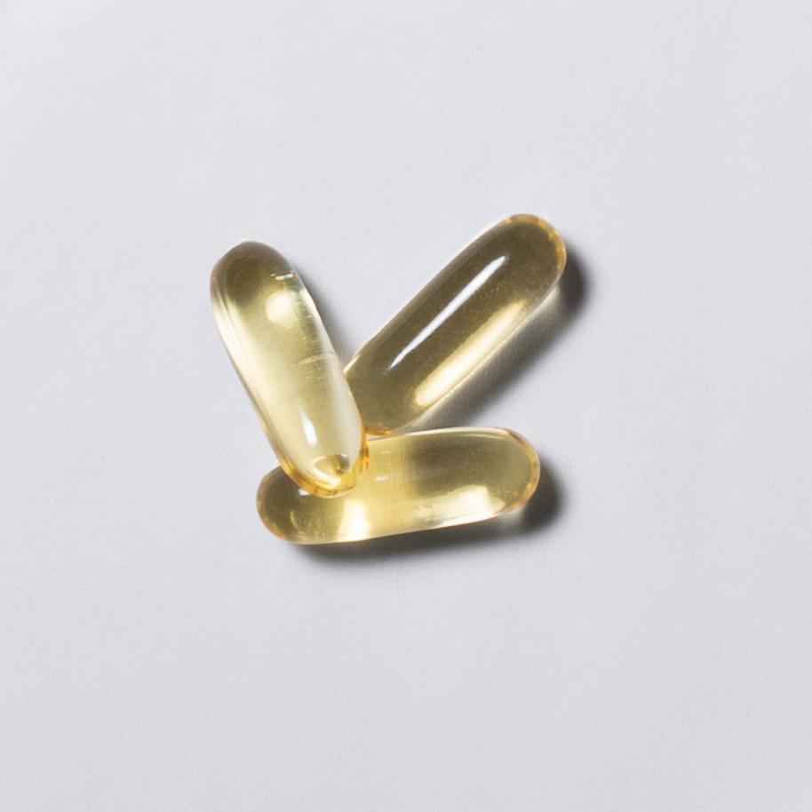 Gelbe Omega-3 Softgel-Kapseln von neotes im Close-up auf hellem Hintergrund